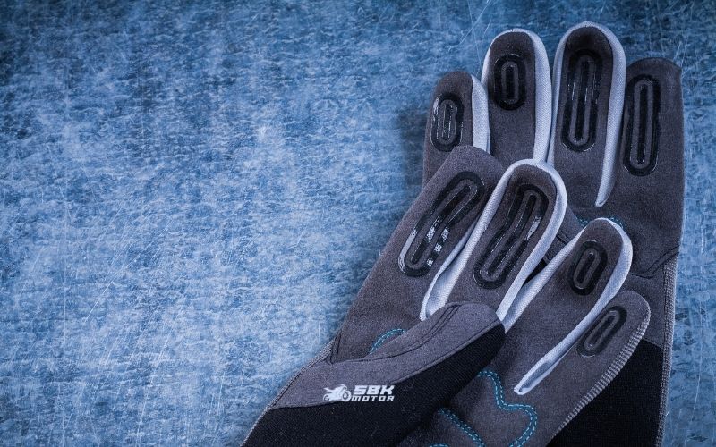 Hangi Standartlar? (EN 13594, EN ISO 21420 ve KP)  CE’nin “hangi kurala göre” verildiğini anlamak için eldivenin iç etiketine bakarız. Motosiklet eldivenlerinin temel performans standardı EN 13594:2015’tir (Protective gloves for motorcycle riders). Bu standardın iki performans seviyesi vardır:  Level 1: Daha az ergonomik kısıtlamayla temel koruma.  Level 2: Daha yüksek koruma, fakat genellikle biraz daha hacim/ağırlık. Ayrıca KP (Knuckle Protection) ibaresi eklem/mafsal korumasının darbe testini geçtiğini gösterir. Level 2belgesi almak isteyen eldivenlerde knuckle darbe testi zorunludur; Level 1’de isteğe bağlıdır.  Buna ek olarak tüm koruyucu eldivenler için geçerli genel gereklilik standardı EN ISO 21420:2020’dir (eski EN 420’nin yerini almıştır). Bu standart, tasarım–yapı, sağlığa zararsızlık (ör. kimyasal kısıtlar, pH, krom VI, DMFa), sezgisel konfor ve beden ölçüleri, işaretleme ve bilgi gibi yatay kuralları koyar. Kısaca: EN ISO 21420 “nasıl bir eldiven olmalı” sorusunu, EN 13594 ise “motosiklet kazasında nasıl korumalı” sorusunu yanıtlar.